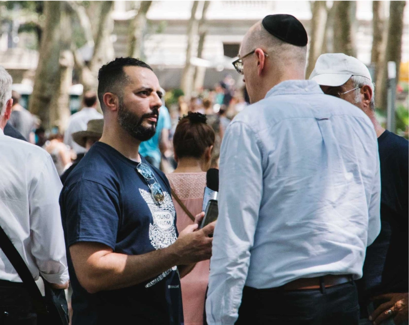 A man talks to another Jewish man on the streets of NYC