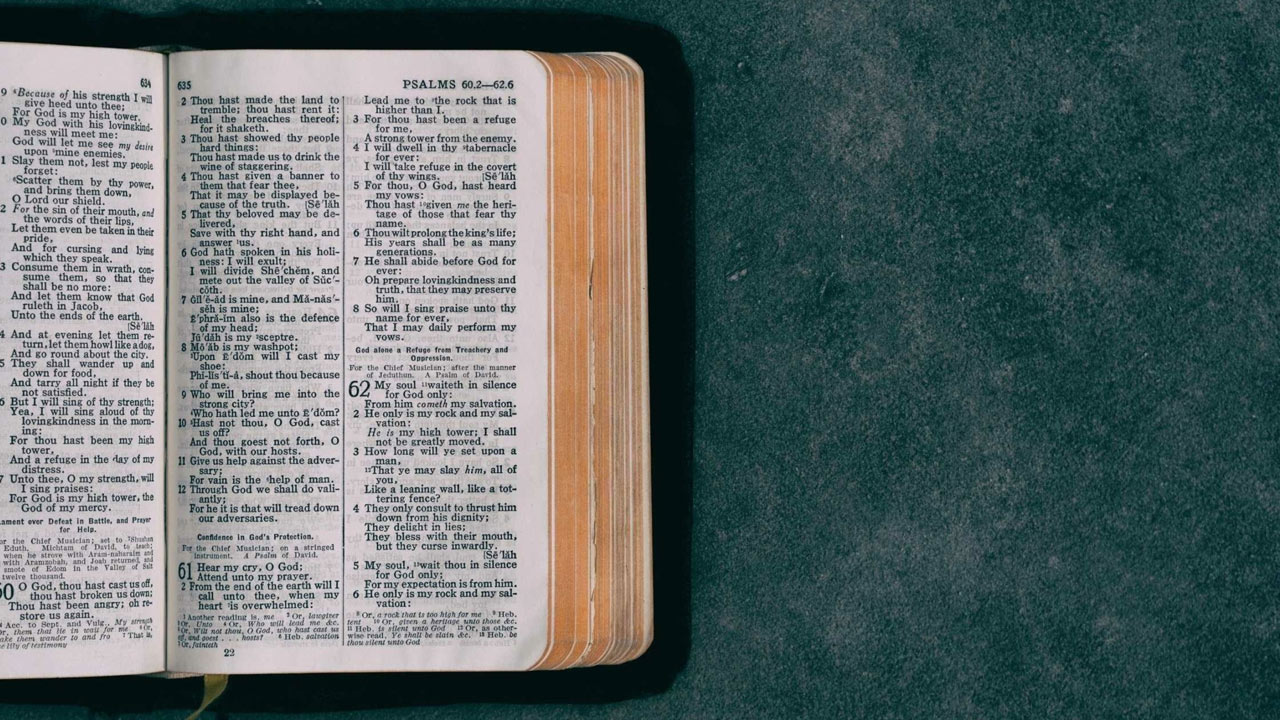 A bible sits on a table, open to Psalm 62